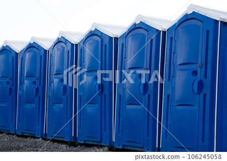 Row of blue portable chemical booths of bio toilets. Portable mobile toilets for construction sites 106245058