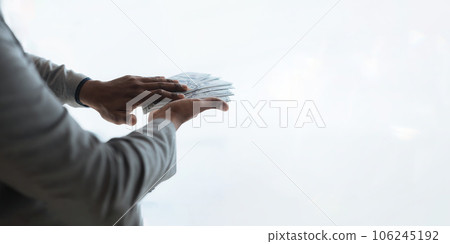 businessperson rich man ethnicity diversity displaying a spread of cash over a green vintage background 106245192