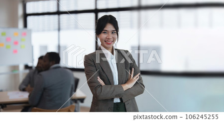 Pretty young Asian business woman standing a confidence in the office with a diversity ethnicity background Pretty young Asian business woman standing a confidence in the office with a diversity ethnicity background 106245255