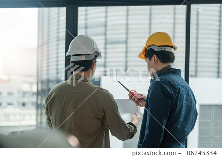 Two engineer man checking work with walkie-talkie for communication in the construction site 106245334