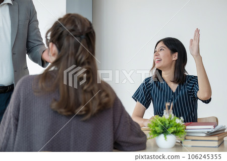 Positive friendly African American English tutor giving language courses to group of interested adults of different ages and nationalities sitting around table in classroom, Education concept 106245355