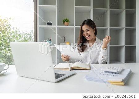 Happy asian businesswoman raising hands with victory smiling happily with documents in hand. The concept of success at work Happy asian businesswoman raising hands with victory smiling happily with documents in hand. The concept of success at work 106245501