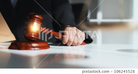 Photography of a judge hold judges gavel with justice lawyers at law firm in background. concepts of law 106245528