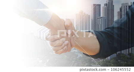 Close up of businessman handshake on abstract city background. Teamwork concept. Double exposure Close up of businessman handshake on abstract city background. Teamwork concept. Double exposure 106245552