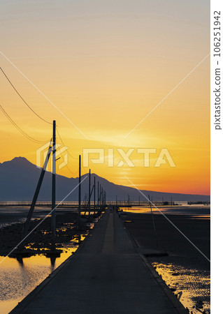 [Kumamoto Prefecture] A straight road leading to the sea Nagabeda Kaidokoro dyed in the setting sun 106251942