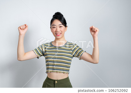 Young asian woman raising arms while smiling and screaming to celebrate after successfully work 106252092