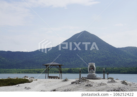 A memorial statue standing on the sandy beach of Lake Usori in Mt. Osore A memorial statue standing on the sandy beach of Lake Usori in Mt. Osore 106252422