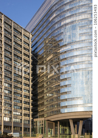 The facade of a modern multi-storey building with reflections in the windows 106253493