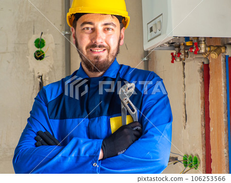 Portrait of worker or engineer in blue work clothes and yellow safety helmet 106253566