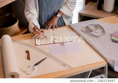 Asian tailor women creative and designing new fashion collection while drawing sketch in notebook Asian tailor women creative and designing new fashion collection while drawing sketch in notebook 106253647
