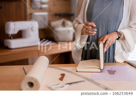 Asian tailor women creative and designing new fashion collection while drawing sketch in notebook Asian tailor women creative and designing new fashion collection while drawing sketch in notebook 106253649