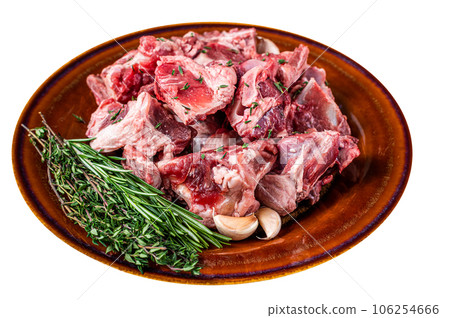 Raw mutton meat diced for goulash or stew with bone on a rustic plate. High quality Isolate, white background. 106254666