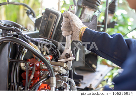 Close up view of hydraulic pipes of heavy industry machine. Mechanic repairing hydraulic hose in drilling machine, Man in hard hat industrial worker. Hydraulic maintenance concept. 106256934