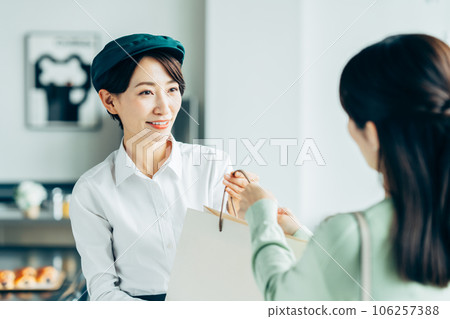 Middle-aged woman handing over goods 106257388