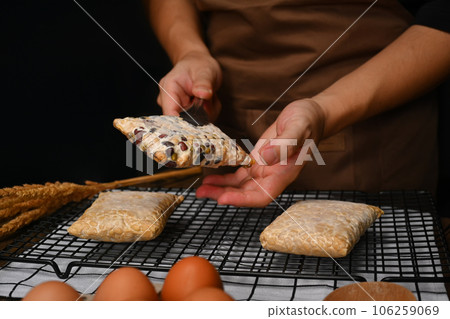 Man in apron holding Tempeh on black background. Vegan appetizers, traditional Indonesian soy product Man in apron holding Tempeh on black background. Vegan appetizers, traditional Indonesian soy product 106259069
