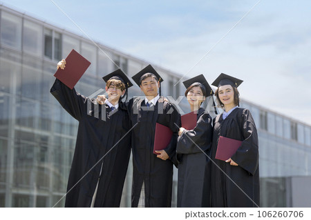 Four students wearing academic gowns Graduation ceremony image 106260706