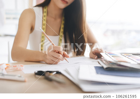 Closeup beautiful hand young adult women fashion designer sketching idea with pencil 106261595