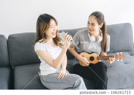 Southeast asian people couple relax lifestyle playing music on sofa life moments at home 106261715