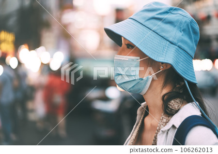 Woman traveller wear face mask for covid-19 traveling in local city on summer day Woman traveller wear face mask for covid-19 traveling in local city on summer day 106262013