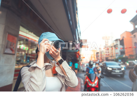 Young adult asian woman traveller backpack using camera photography in city Young adult asian woman traveller backpack using camera photography in city 106262036