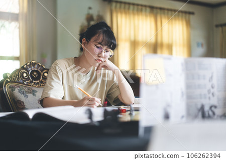 Young adult asian woman focus on role playing tabletop and board games Young adult asian woman focus on role playing tabletop and board games 106262394