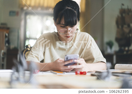 Young adult asian woman using smartphone for role playing tabletop and board game Young adult asian woman using smartphone for role playing tabletop and board game 106262395