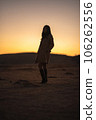 Kusasenri at sunset, silhouette of a woman in a coat 106262556