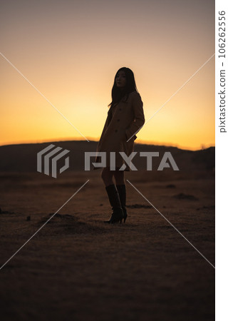 Kusasenri at sunset, silhouette of a woman in a coat Kusasenri at sunset, silhouette of a woman in a coat 106262556