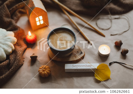 Autumn cozy home interior with a cup, candles, plaid. Hygge home decor. Halloween and Thanksgiving concept  106262661