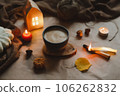 Autumn cozy home interior with a cup, candles, plaid. Hygge home decor. Halloween and Thanksgiving concept  106262832
