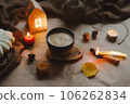 Autumn cozy home interior with a cup, candles, plaid. Hygge home decor. Halloween and Thanksgiving concept  106262834