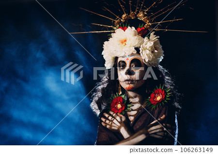 Woman with mexican skull halloween makeup on face. Day of the dead aka Dia de los Muertos and halloween concept. 106263149