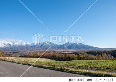 Autumn snow-capped mountains and rolling hills Mt. Tokachi 106264441