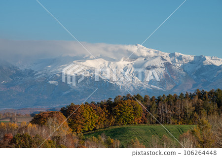 Colorful autumn hills and snow-capped mountains Mt. Tokachi 106264448