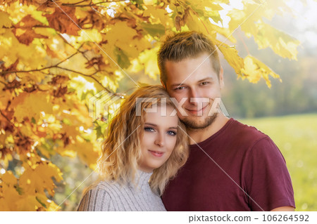 Young man and woman are posing in the autumn park. 106264592