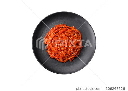 Dried squid chopped into slices and seasoned with sesame seeds and spices Dried squid chopped into slices and seasoned with sesame seeds and spices 106268326