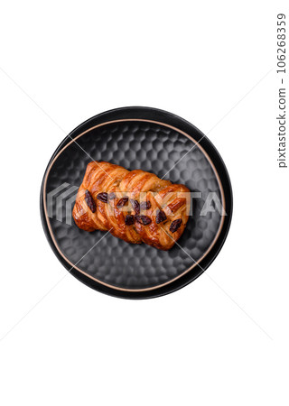 Delicious fresh baked pigtail bun with nuts and syrup 106268359