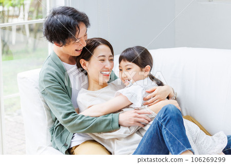Smiling parent and child sitting on the sofa in the living room Smiling parent and child sitting on the sofa in the living room 106269299