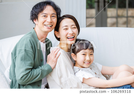 Smiling parent and child sitting on the sofa in the living room Smiling parent and child sitting on the sofa in the living room 106269318