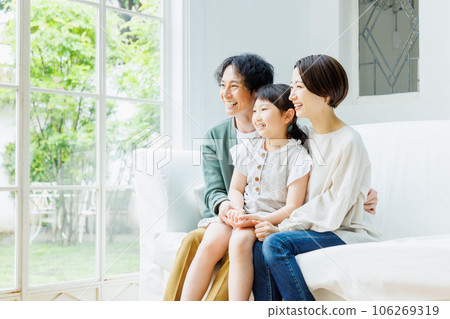 微笑的父母和孩子坐在客廳的沙發上 微笑的父母和孩子坐在客廳的沙發上 106269319