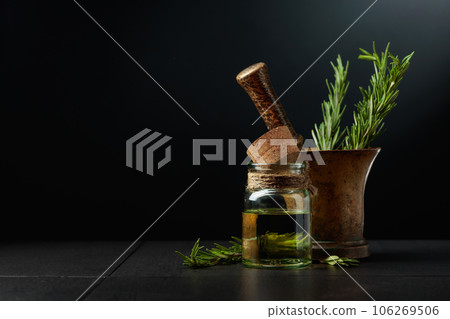 Bottle of rosemary aromatherapy oil extract with fresh rosemary branches. 106269506