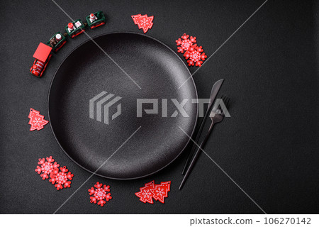 Empty ceramic black plate with christmas decoration elements 106270142