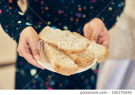 Whole-grain bread cut on a plate, the child holds out a plate. Fresh bread close-up. The concept of healthy eating and traditional bakery. High quality photo Whole-grain bread cut on a plate, the child holds out a plate. Fresh bread close-up. The concept of healthy eating and traditional bakery. High quality photo 106270840