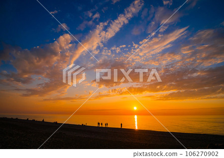 People are looking at dramatic sunset over the sea surface in the evening People are looking at dramatic sunset over the sea surface in the evening 106270902