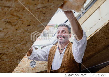 Carpenter fixing insulation material on roof window Carpenter fixing insulation material on roof window 106271222