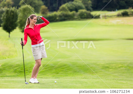 Female golfer shielding eyes on golf course 106271234