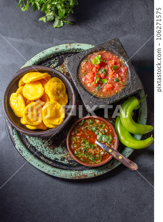 Sopaipilla. Latin American food. Traditional chilean homemade pumpkin sopaipillas with typical salsas - chancho en piedra tomato sauce in stone mortar and spicy pebre 106271575