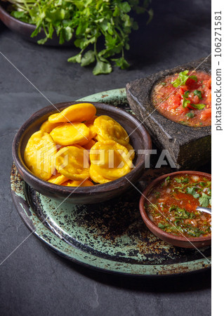 Sopaipilla. Latin American food. Traditional chilean homemade pumpkin sopaipillas with typical salsas - chancho en piedra tomato sauce in stone mortar and spicy pebre 106271581