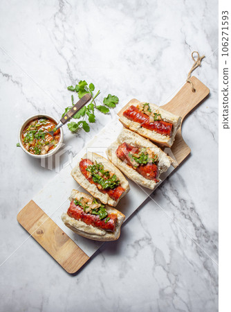 Chilean and Argentinian food. Traditional choripan with spicy pebre, chorizo sandwich with chorizo sausages and bread. Chilean and Argentinian food. Traditional choripan with spicy pebre, chorizo sandwich with chorizo sausages and bread. 106271593
