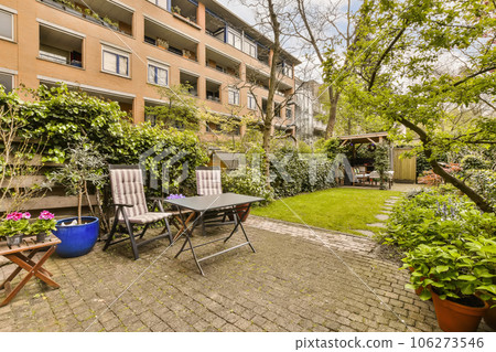 an outdoor patio with chairs, tables and plants in the fore - image is taken from property listing page on real estate 106273546